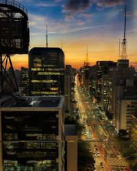 City street and buildings against sky during sunset