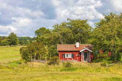 Red idyllic cottage with wooden fence