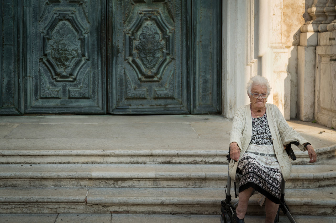 WOMAN STANDING AGAINST DOOR