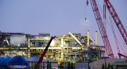 Cranes at construction site against sky