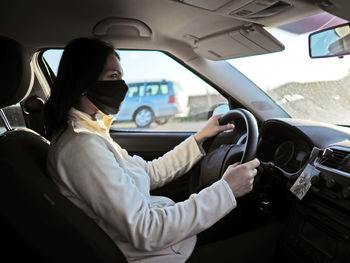 Midsection of woman using mobile phone while sitting in car