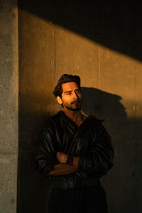 Young man standing against wall