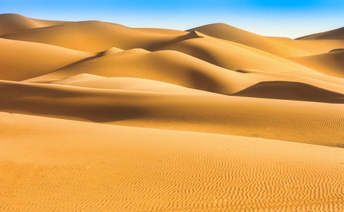 Sand dune in desert against sky