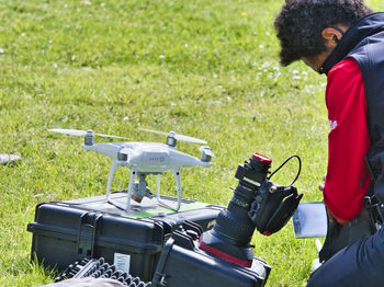 Side view of man photographing on field