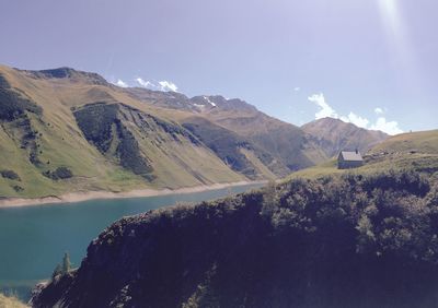 Scenic view of river and mountains against sky