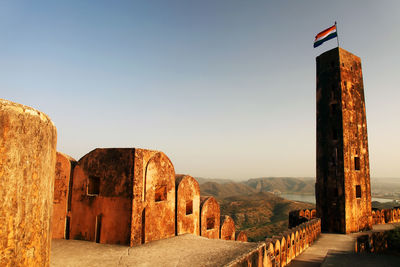 Indian flag on column at jaigarh fort against clear sky