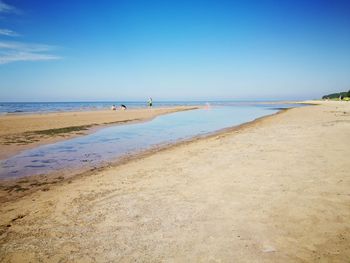 Scenic view of beach against clear blue sky