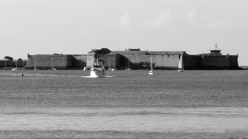 Building by sea against clear sky