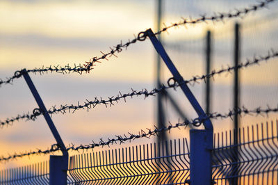 Close-up of barbed wire against sky