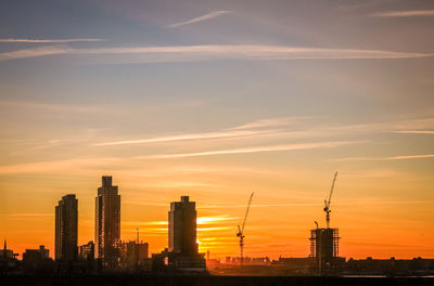 Silhouette buildings against sky during sunset