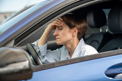 Portrait of young woman sitting in car