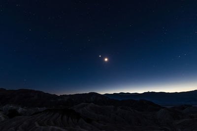 Scenic view of mountains against clear sky at night