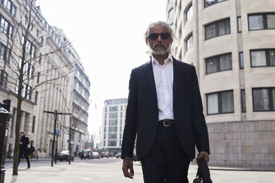 Uk, london, uk, portrait of senior businessman walking in the city