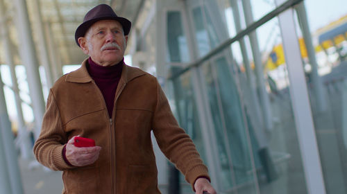 Portrait of man wearing hat standing against blurred background