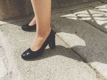 Low section of woman walking on road