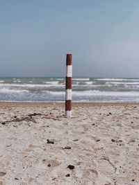 Lifeguard hut on beach against sky