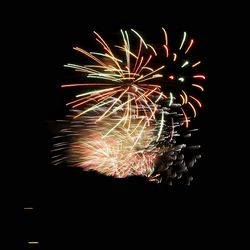 Low angle view of firework display against sky at night