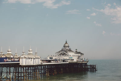 Eastbourne pier at beach against sky