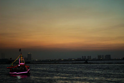 Ship in sea against sky during sunset