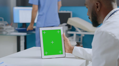 Midsection of doctor using digital tablet at hospital