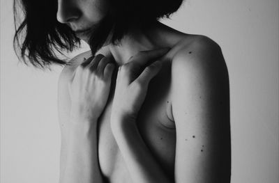 Close-up of shirtless young woman over white background