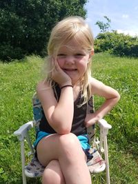 Portrait of a smiling girl sitting on field