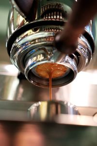 Close-up of hand pouring coffee in cup