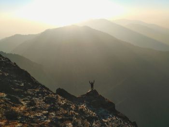 Scenic view of silhouette mountains at sunset