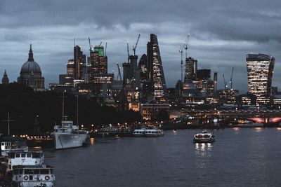 City at waterfront against cloudy sky