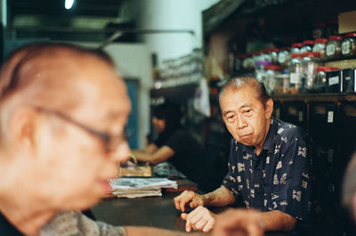 Portrait of man holding camera in restaurant