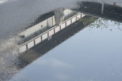 Reflection of bridge on water in puddle
