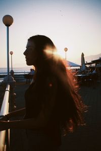 Low angle view of young woman looking through window