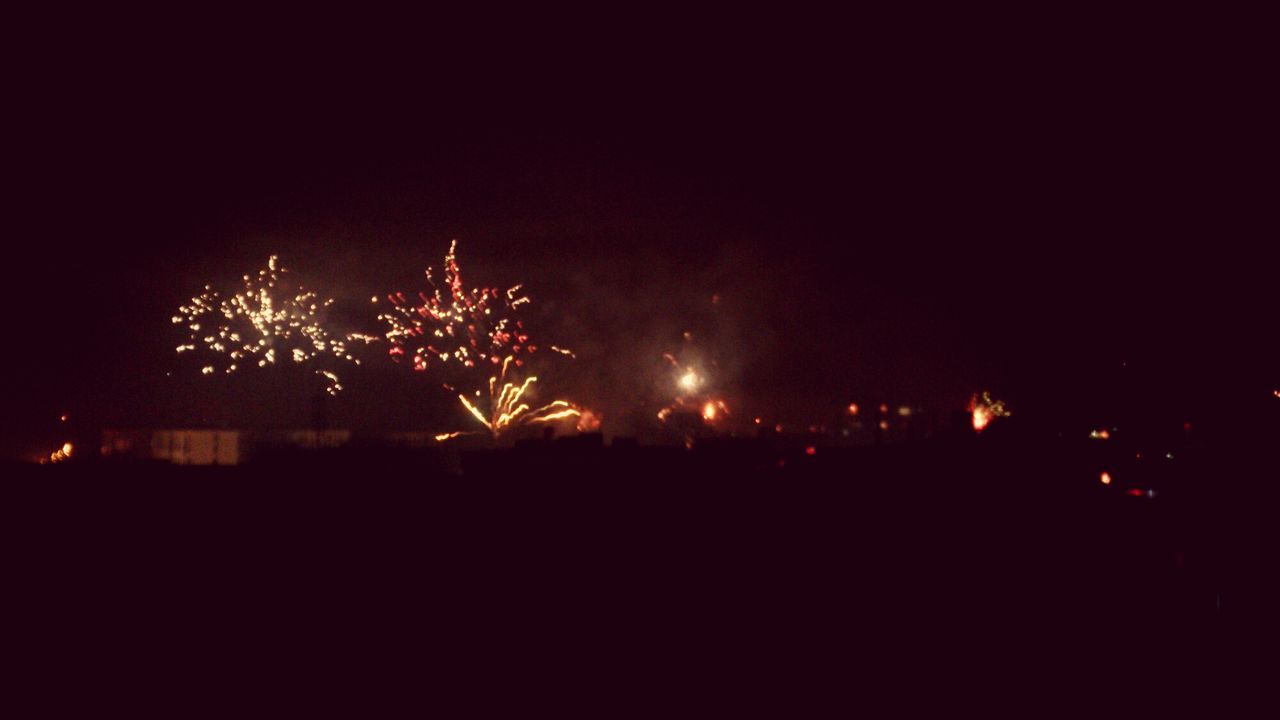 night, illuminated, firework display, celebration, exploding, building exterior, long exposure, copy space, glowing, dark, firework - man made object, city, sky, clear sky, built structure, arts culture and entertainment, architecture, light - natural phenomenon, light, outdoors