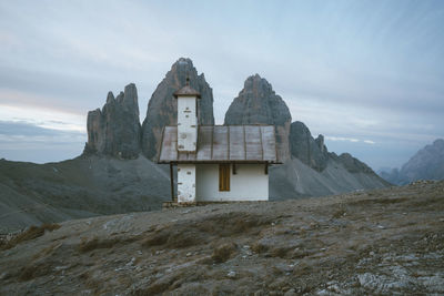 Cottage on mountain peak against sky