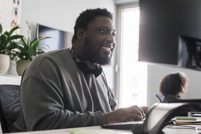 Excited male business professional working on computer at office