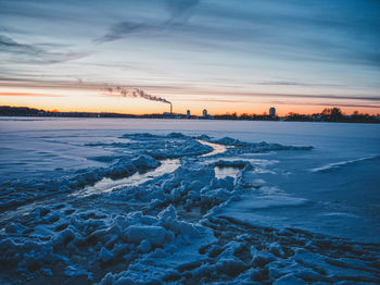 Scenic view of frozen sea against sky during sunset