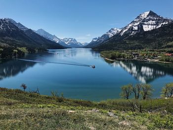 Scenic view of lake and mountains against clear blue sky