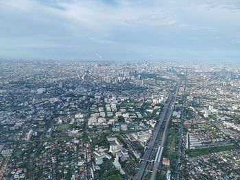 High angle view of crowd by city buildings against sky