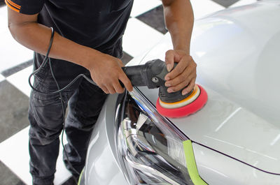 High angle view of mechanic polishing car