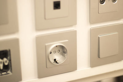 Close-up of electric lamp on wall at home