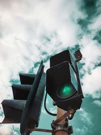 Low angle view of road signal against sky