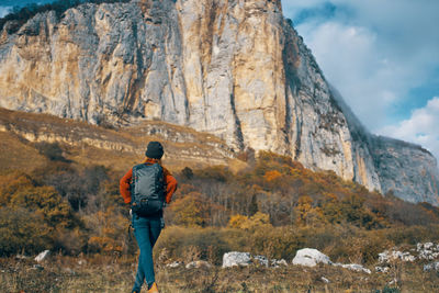 Rear view of man looking at mountain against sky