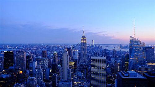 Buildings in city against sky at dusk