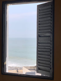 Scenic view of sea against sky seen through window