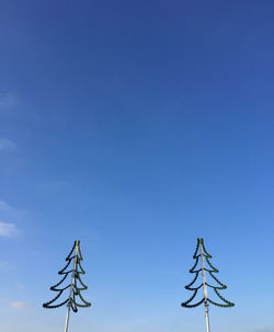 Low angle view of electricity pylon against blue sky