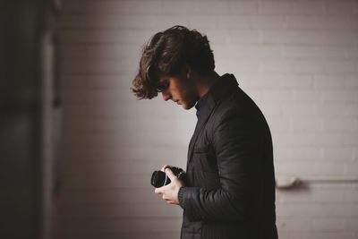 Side view of man using camera
