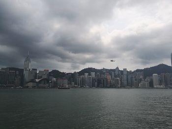 Buildings by sea against sky in city