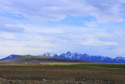 Scenic view of field and mountains against sky