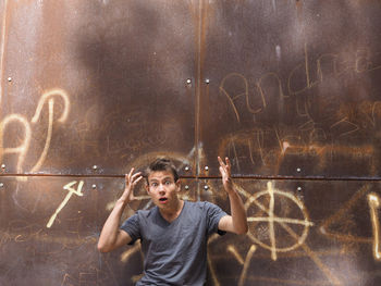 Portrait of shocked man against rusty metal