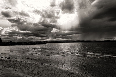 Scenic view of sea against storm clouds